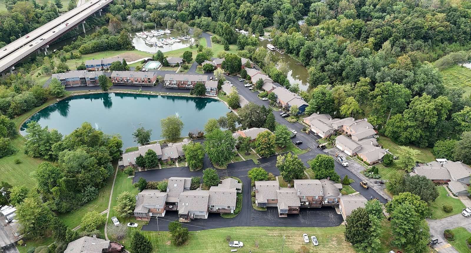Drone view of a lakeside condo community with new asphalt drives